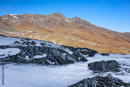 The frozen stream with a view of Pizzo Ferrè, Central Alps, Italy photo