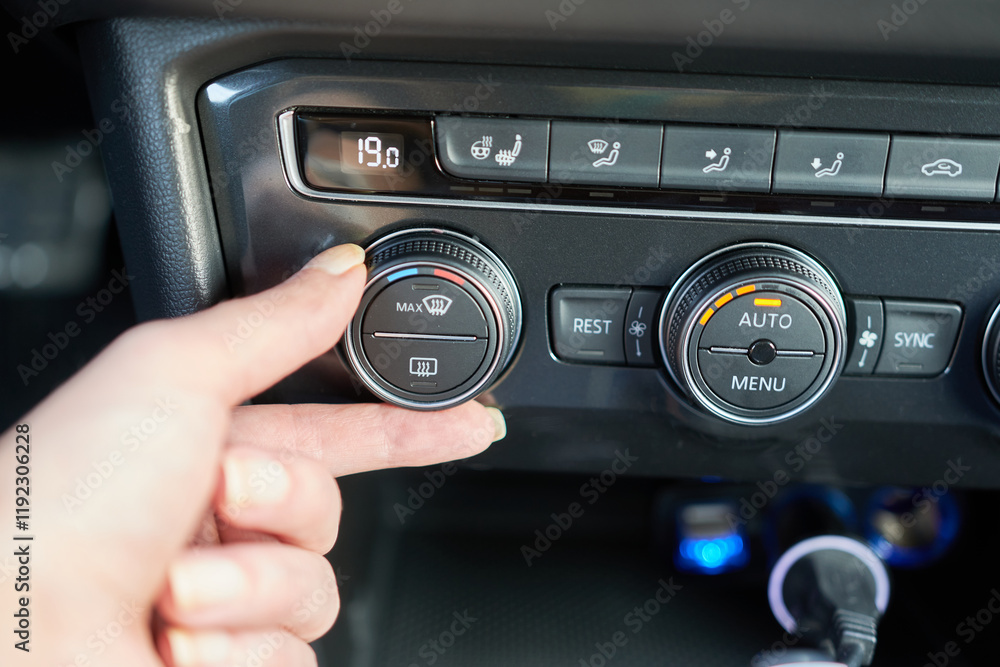 Fototapeta premium Close-up of female hand adjusting the air conditioning in a car