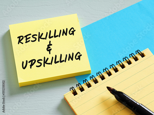 Reskilling and upskilling written on sticky note, training and education concept photo