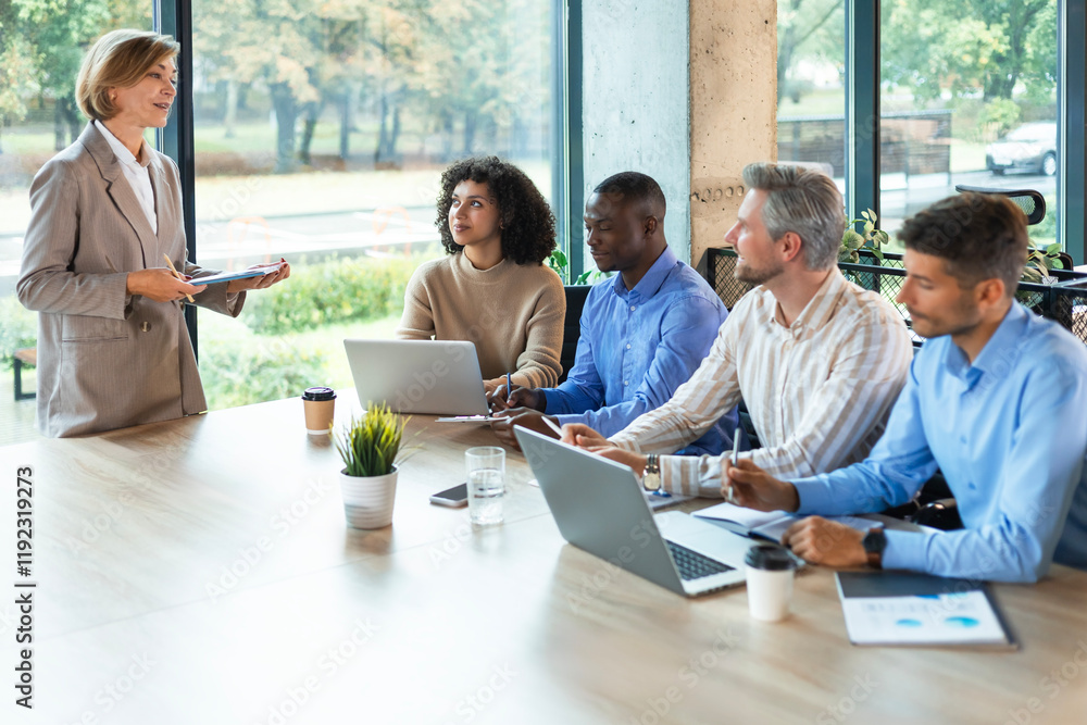 Business meeting - manager discussing work with her colleagues. Business meeting - manager discussing work with her colleagues.