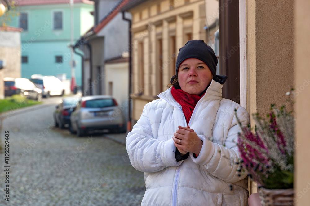 A plus-size woman strolling through the streets of a small European town.