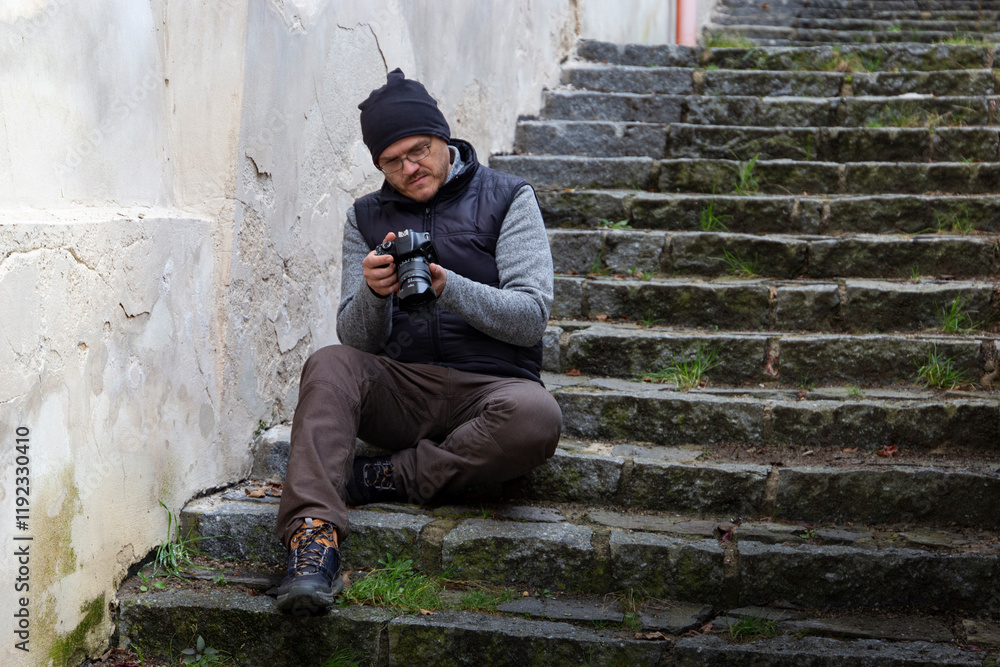 A man with a camera walking through an autumn city.