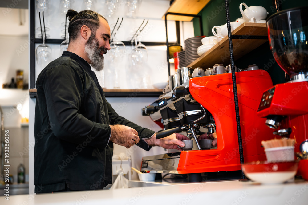 Fototapeta premium Professional barista in black apron working in restaurant. Portrait of happy barmen who is making coffee in his bar.