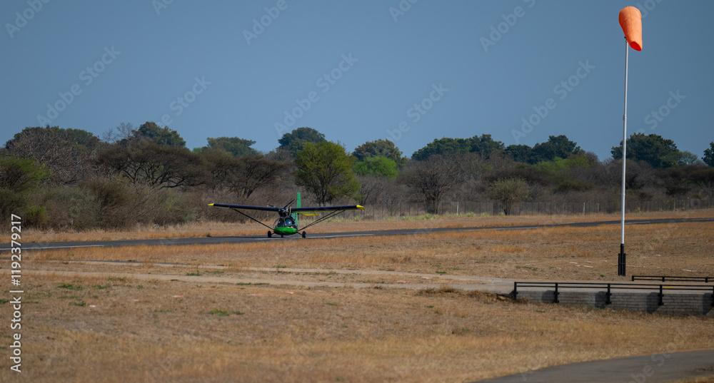 Ultralight aircraft or Microlight aircraft taking off on the runway in Hoedspruit South Africa