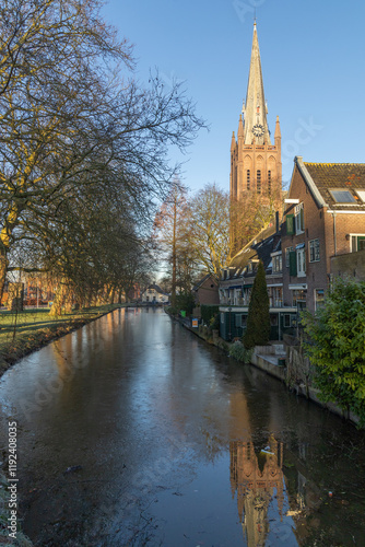 Sint Nicolaasbasiliek church IJsselstein surrounded by local houses and canal. IJsselstein, the Netherlands. 11 January 2025.  photo