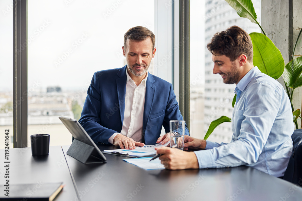 Happy businessmen having discussion over data in office Happy businessmen having discussion over data in office