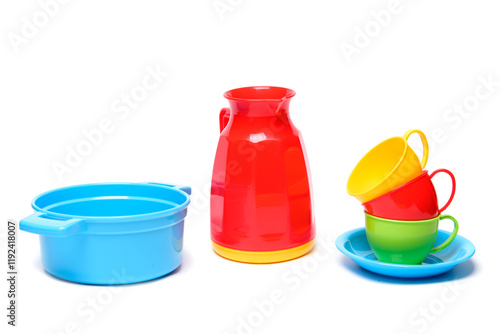 Plastic multicoloured toy dishes on a white background