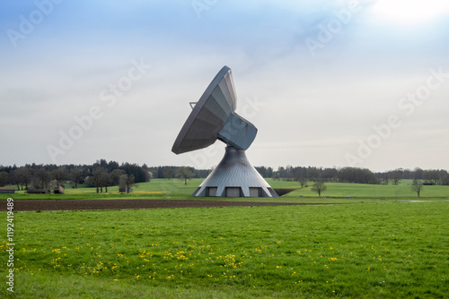 Large satellite dish amidst meadow photo