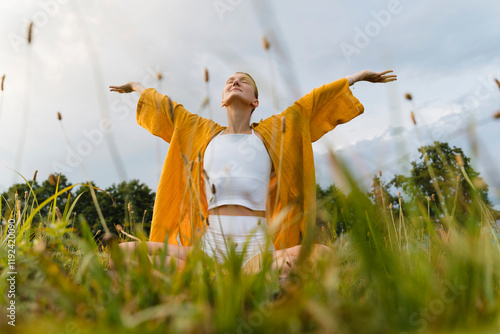 Smiling woman practicing yoga in nature photo