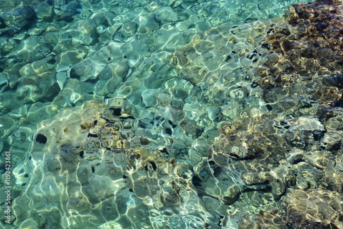 Canvas Print A shallow sea with clear turquoise water revealing stones