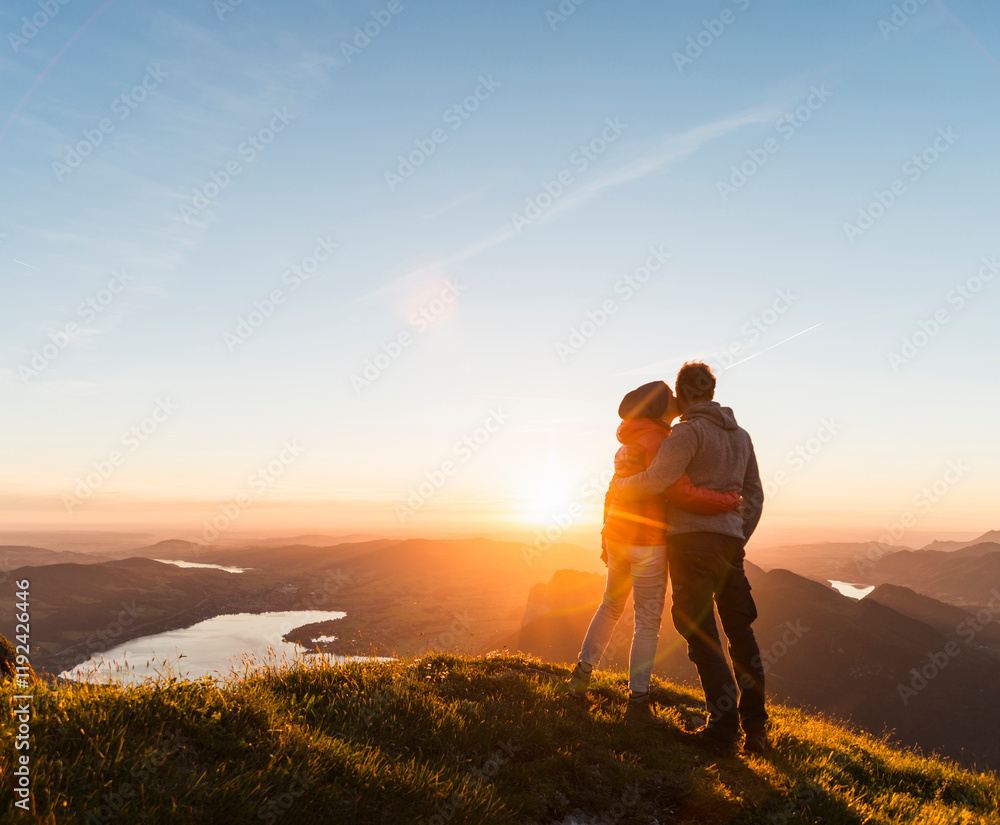 Couple embracing and looking at view from mountain Couple embracing and looking at view from mountain