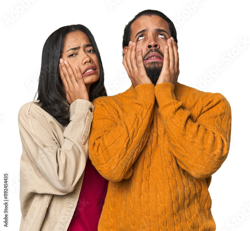 Young Latino couple in studio whining and crying disconsolately. photo