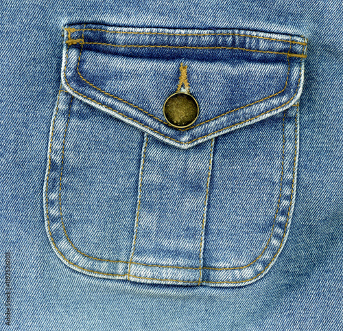 Blue stone washed denim pocket and metal button detail cotton fabric texture background photo