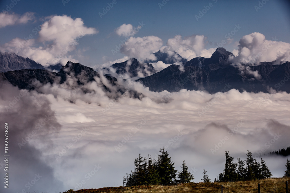 Fog envelops the majestic mountains in Saalbach Hinterglemm, Austria, creating a serene and mystical landscape in late afternoon Fog envelops the majestic mountains in Saalbach Hinterglemm, Austria, creating a serene and mystical landscape in late afternoon