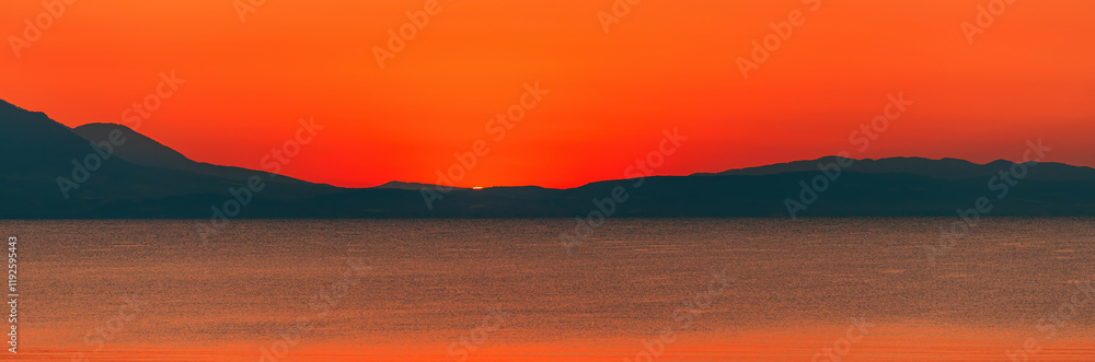 Fototapeta premium Beautiful dawn at Aegean sea, vibrant orange sky moments before the sunrise seen from Vrasna in Greece