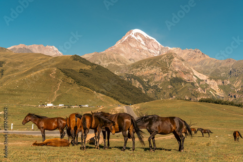 Wallpaper Mural A herd of horses are grazing in a field with a mountain in the background. The scene is peaceful and serene, with the horses standing close together and the mountain providing a beautiful backdrop Torontodigital.ca