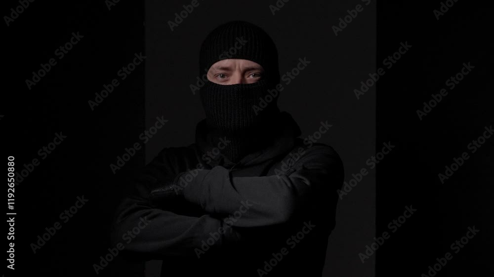 Man in Black Mask with Arms Crossed in Darkness Man in Black Mask with Arms Crossed in Darkness