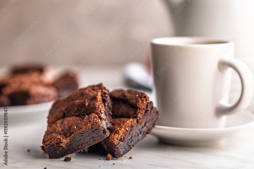 Homemade chocolate brownies and coffee cup on kitchen table. Homemade chocolate brownies and coffee cup on kitchen table.