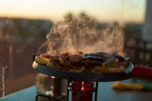 Sizzling barbecue grill with steaks and vegetables against a sunset backdrop, New Orleans, USA photo