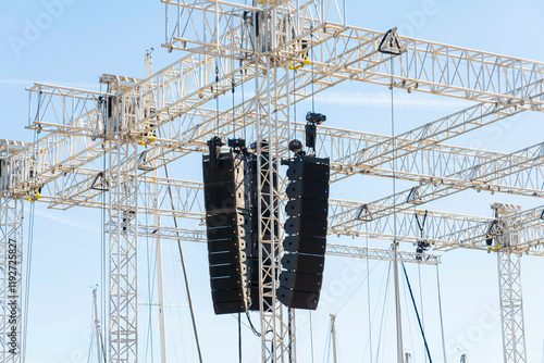 Array of professional line array speakers suspended from a metal truss at an outdoor event, Marseille, France