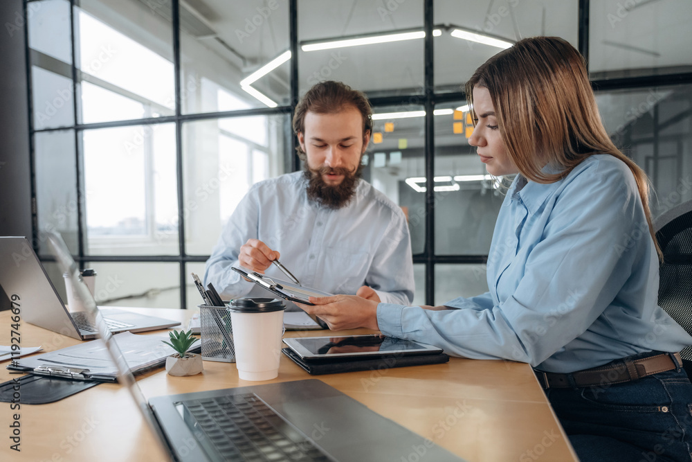 Friendly atmosphere, cup of coffee and laptops. Man and woman are in the office together