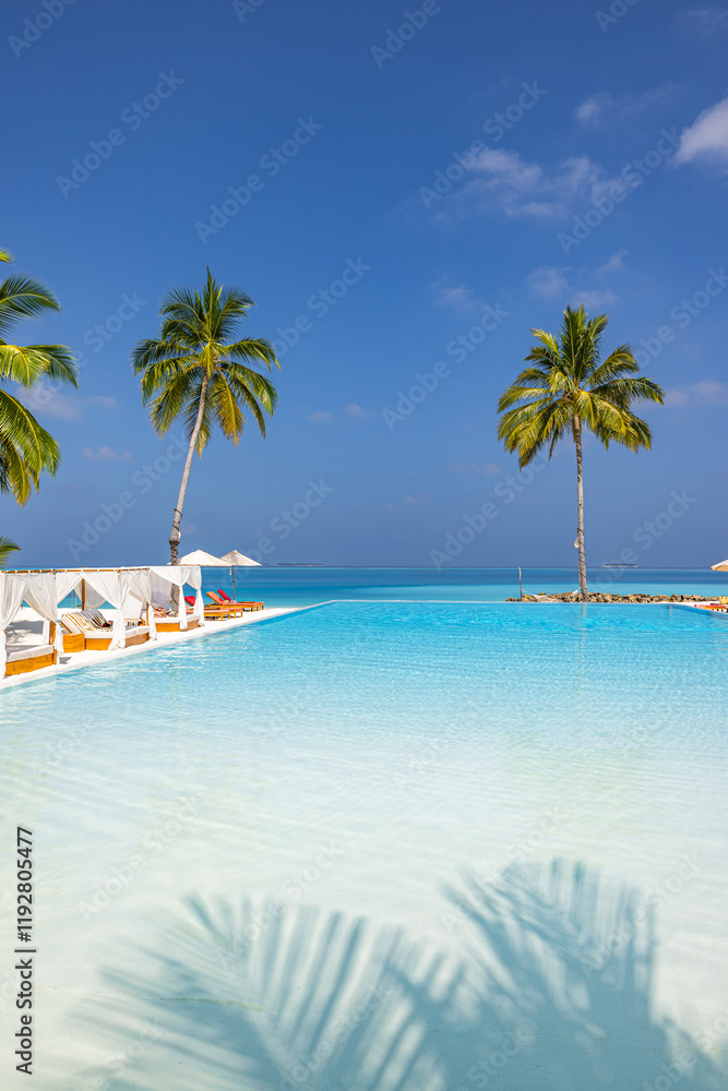 Naklejka premium Amazing landscape, swimming pool blue sky with clouds. Tropical resort hotel in Maldives. Fantastic relaxing peaceful vibes, chairs, bed under umbrellas and palm tree leaves. Luxury vacation tourism