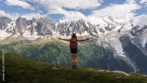 Woman with her arms crossed on top of the mountain in front of the Montblanc massif