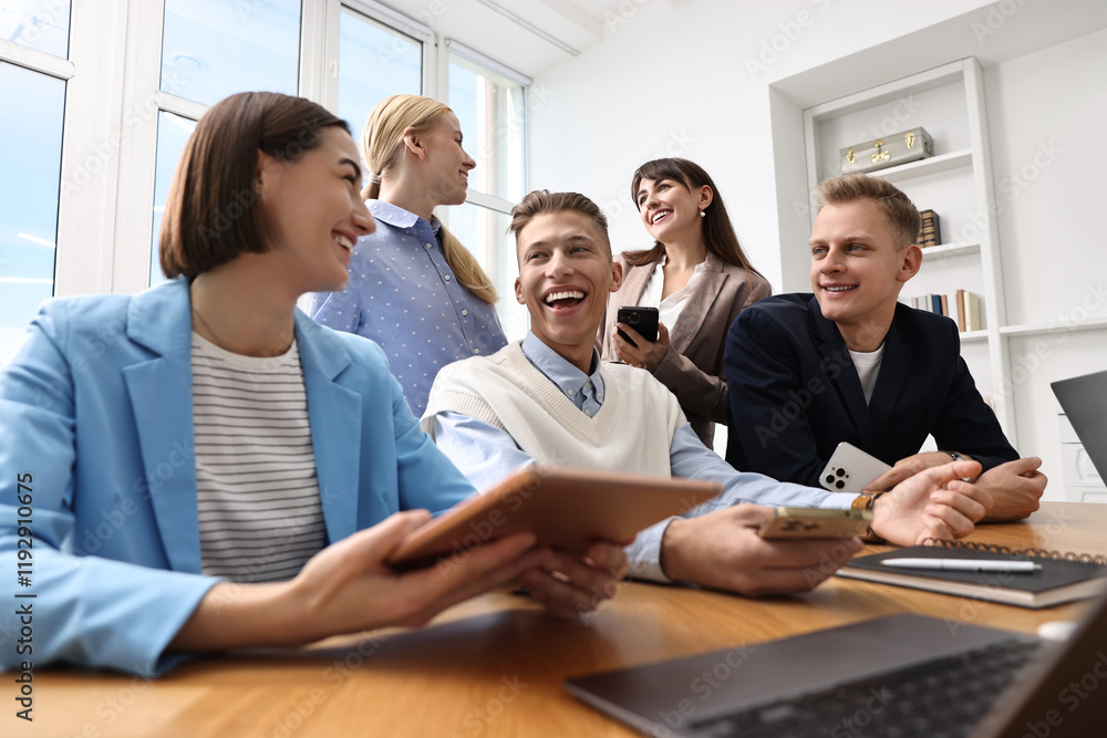 Group of people using different gadgets at wooden table in office. Modern technology Group of people using different gadgets at wooden table in office. Modern technology