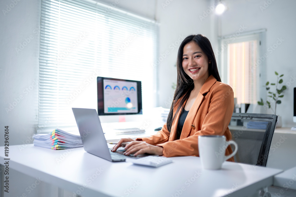 A woman is sitting at a desk with a laptop and a cup of coffee A woman is sitting at a desk with a laptop and a cup of coffee