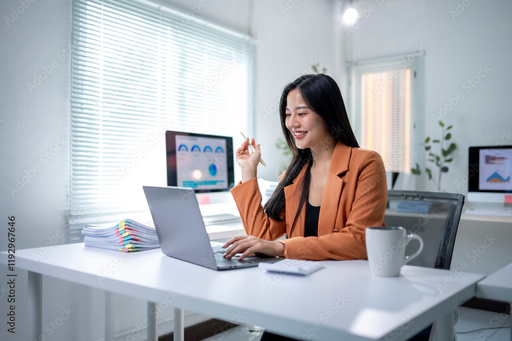 A woman is sitting at a desk with a laptop and a cup of coffee A woman is sitting at a desk with a laptop and a cup of coffee