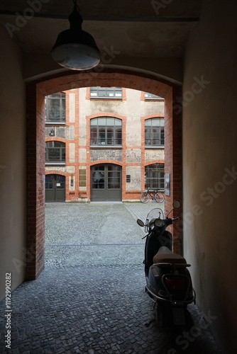 Sanierter Altbau mit Galerie, Loft und Büro in einem Hinterhof mit altem Mauerwerk und Kopfsteinpflaster und Motorroller im Durchgang an der Münzstraße im Stadtteil Mitte in der Hauptstadt Berlin photo