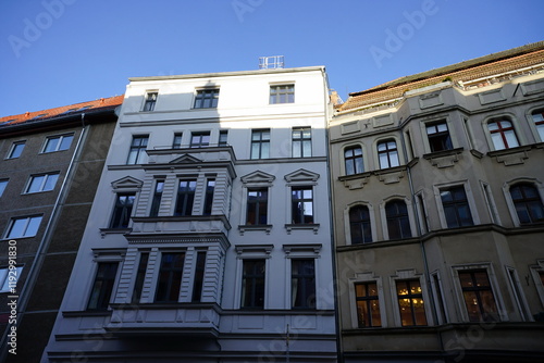 Blick aus dem Hinterhof auf schöne sanierte Fassaden alter Wohnhäuser in Weiß und Naturfarben vor blauem Himmel im Sonnenschein im Stadtteil Mitte in der Hauptstadt Berlin photo