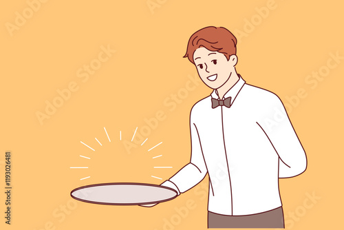 Man waiter with empty tray holds hand behind back, suggesting that you visit fabulous restaurant with delicious food. Guy waiter in formal wear with bow tie, smiling and looking at screen