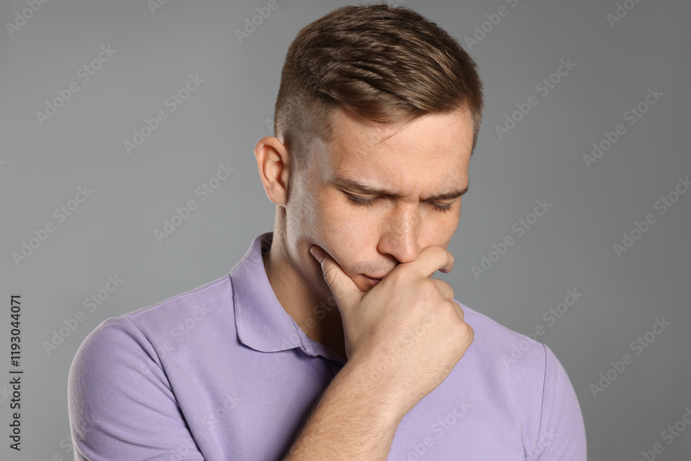 Distressed young man crying on grey background Distressed young man crying on grey background