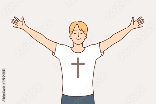 Religious man feels free and empowered by faith, dressed in t-shirt with crucifix on chest