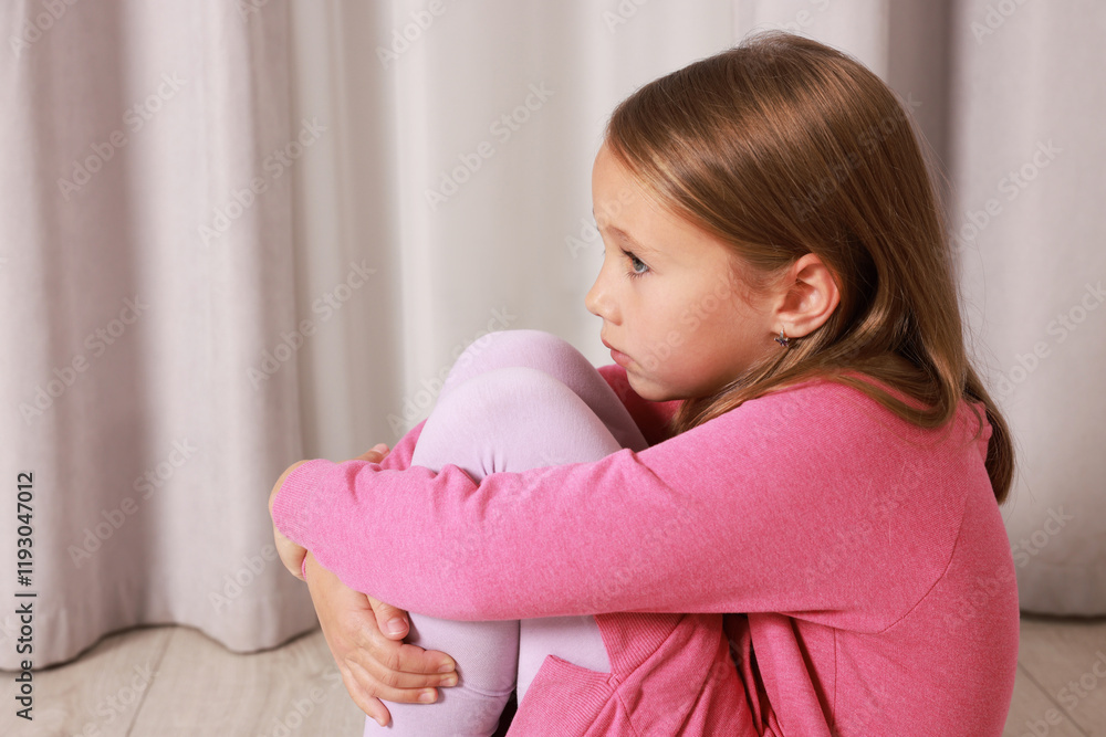 Autism concept. Lonely little girl sitting on floor at home Autism concept. Lonely little girl sitting on floor at home