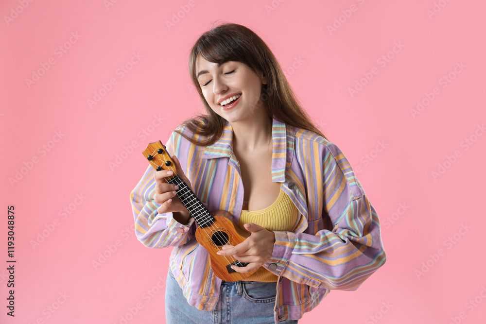 Happy woman playing ukulele on pink background Happy woman playing ukulele on pink background