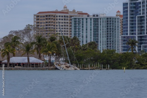 The felled boat sits in the water post hurricane Milton at Bayfront Park Sarasota Florida 2024 photo