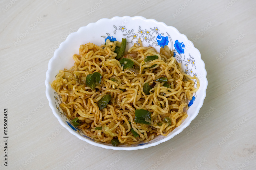 Delicious fried noodles with green bell pepper, tomato, and chili, served in a white bowl. Delicious fried noodles with green bell pepper, tomato, and chili, served in a white bowl.
