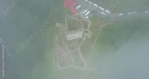 4K aerial video capturing a medieval castle enveloped by a foggy forest, highlighting the mysterious ambiance and ancient architecture amidst the dense woodland. Zilkale, Rize