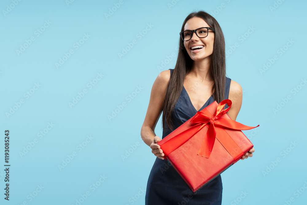 Happy businesswoman holding red gift box on blue background Happy businesswoman holding red gift box on blue background