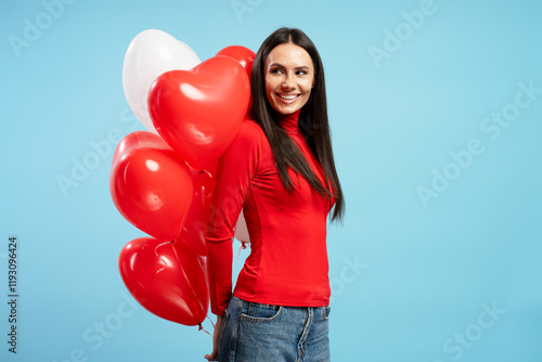 Beautiful woman holding red and white heart shaped balloons smiling and looking backwards