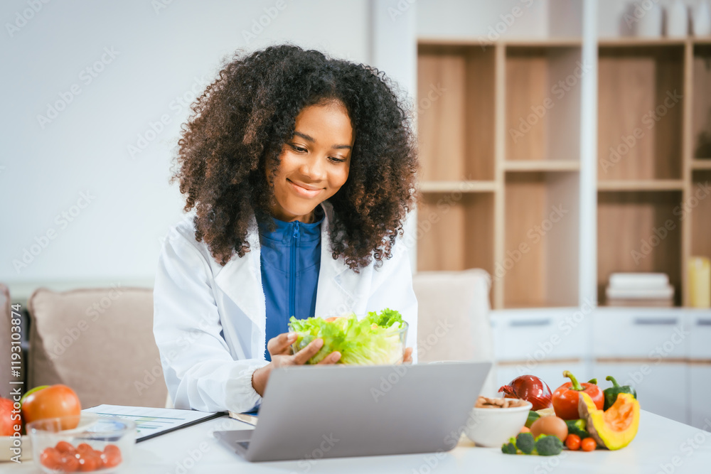 An African American female nutritionist sits at a table, consulting online with patients. She talks about the benefits of eating fruits and vegetables, emphasizing healthy eating and the importance An African American female nutritionist sits at a table, consulting online with patients. She talks about the benefits of eating fruits and vegetables, emphasizing healthy eating and the importance