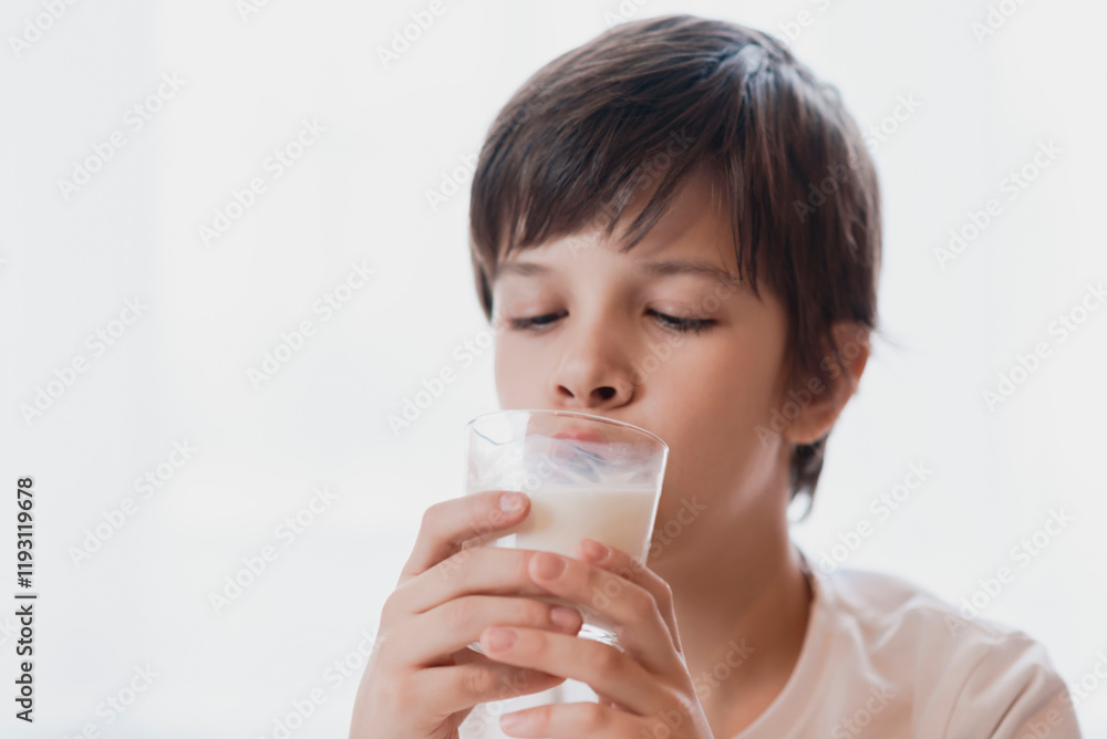 Cute boy drinking milk from a glass at home Cute boy drinking milk from a glass at home