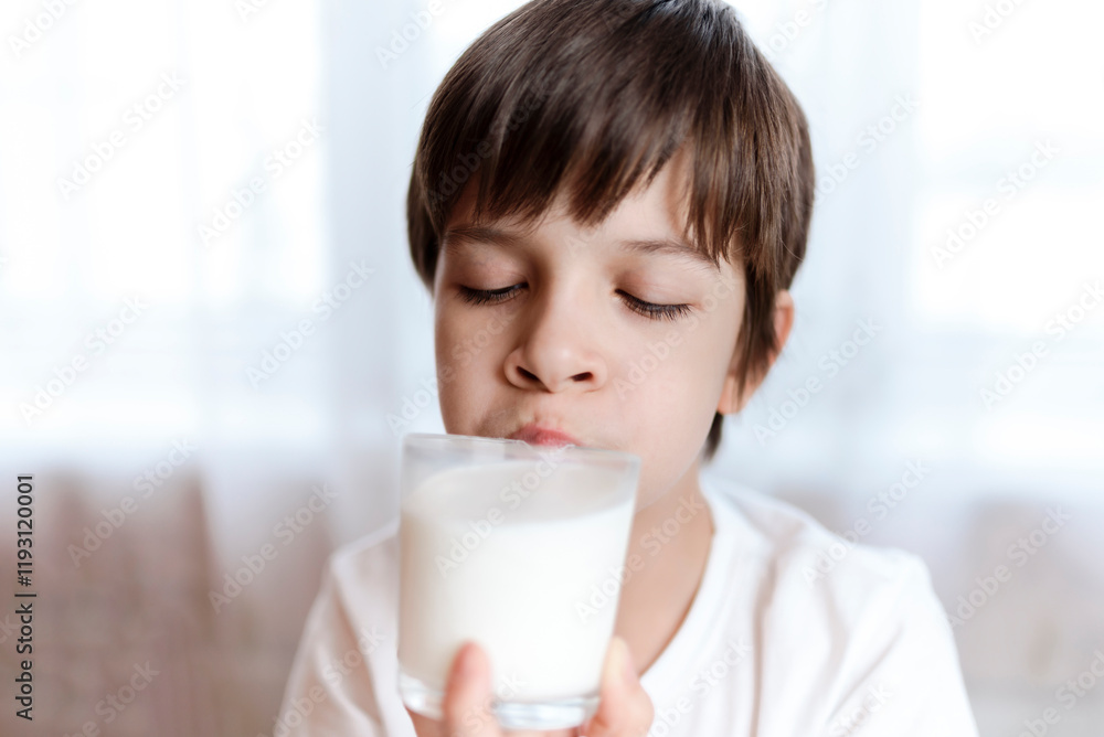 Cute boy drinking milk from a glass at home Cute boy drinking milk from a glass at home