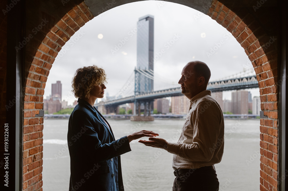 People by the window with Manhattan Bridge in the background, Brooklyn District in New York City - USA