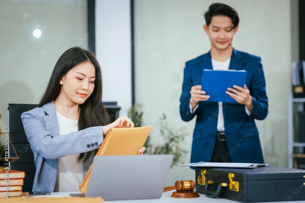 An Asian female lawyer conducts online consultations using a laptop in her office. She reviews legal contracts, advises clients, provides expert legal advice to businesses in Thailand, Japan,China
