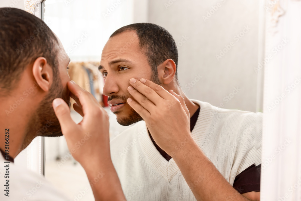 Worried man looking at mirror at home Worried man looking at mirror at home