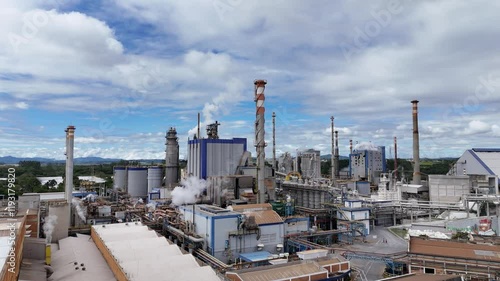 Vídeo com visão aérea de chaminés e caldeiras de uma indústria de papel e celulose em um dia ensolarado, destacando o processo de produção e a emissão de vapor na fábrica photo