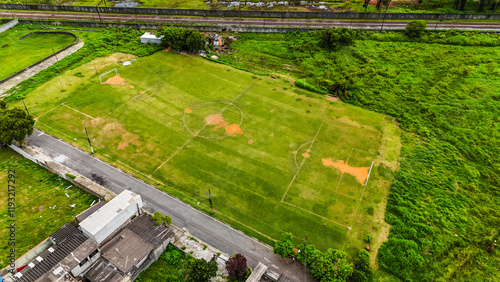 Visão aérea de um campo de futebol de várzea, mostrando a estrutura simples, jogadores em campo e o ambiente rural, representando o futebol amador e comunitário photo